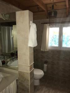 a bathroom with a toilet and a sink at LA CASONA in Villa General Belgrano +7 photos