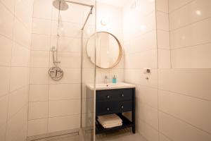 a bathroom with a sink and a shower with a mirror at Orkana 13 Apartments in Zakopane