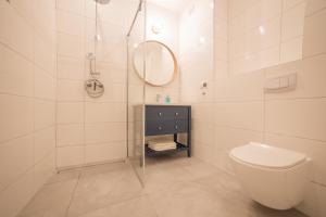 biała łazienka z toaletą i lustrem w obiekcie Orkana 13 Apartments w Zakopanem