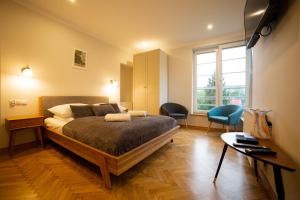 sypialnia z łóżkiem i 2 krzesłami w obiekcie Orkana 13 Apartments w Zakopanem
