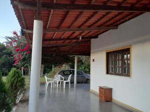 a patio with chairs and a table and a car at Sitio Vila Serrana in Ubajara