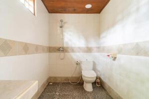 a bathroom with a toilet and a bath tub at Run Gilis in Gili Meno