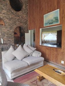 a living room with a couch and a table at Hamba Kancane Ma-Africa Guest House in Graskop