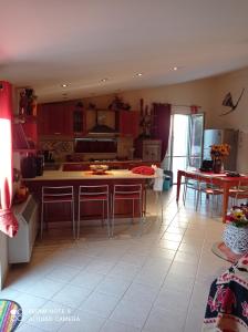 una cucina con armadi rossi, tavolo e sedie di IL MULINO Appartamento Itri centro 150 m2 con ampio terrazzo completo di tutti i comfort a Itri