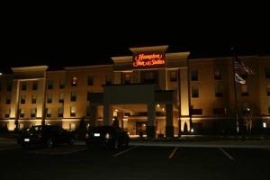 a hotel with a neon sign in a parking lot at Hampton Inn and Suites Peru in Peru