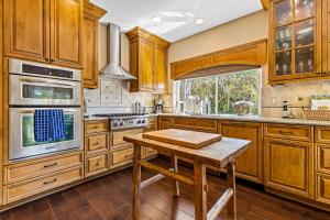 a kitchen with wooden cabinets and a wooden table at La Paloma in Dana Point