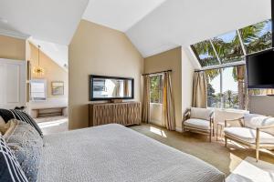 a bedroom with a bed and a tv and a couch at La Paloma in Dana Point