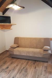 ein Sofa im Wohnzimmer mit Holzböden in der Unterkunft Secluded holiday house Postira, Brac - 17571 in Postira