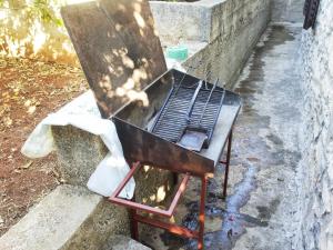 a grill sitting on the side of a wall at Apartments by the sea Brna, Korcula - 17583 in Smokvica