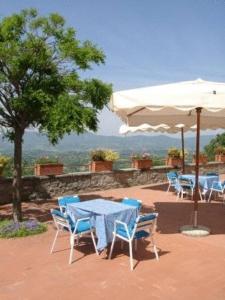 Pian di ScòにあるAgriturismo La Capitataの白い傘付きのテーブルと椅子