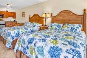 um quarto com duas camas com cobertores azuis e brancos em Bonefish Bay Motel em Marathon