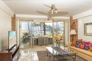 ヌエボ・バジャルタにあるOcean Front Condo with Pool Sleeps 6 Adults-Quinta del Mar 203のソファと天井ファンのあるリビングルーム