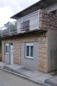 ein Steingebäude mit einem Solarium darüber in der Unterkunft Apartments by the sea Ladjin Porat, Paklenica - 17624 in Starigrad-Paklenica