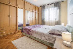 een slaapkamer met een bed en een groot raam bij Apartments with WiFi Rijeka - 17629 in Rijeka