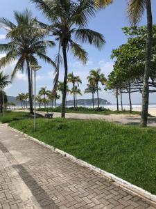un trottoir avec des palmiers sur la plage dans l'établissement Apartamento no Guarujá a 400 mts da praia, à Guarujá