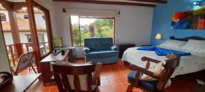 a bedroom with a bed and a desk and a chair at Casa Hotel San Pedro in Villa de Leyva