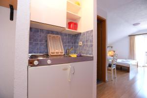 uma cozinha com um lavatório e uma bancada em Apartments by the sea Duce, Omis - 17661 em Duće