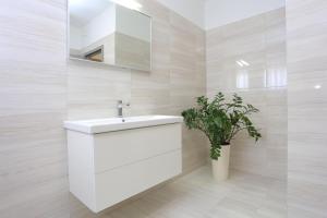 ein Badezimmer mit einem weißen Waschbecken und einem Spiegel in der Unterkunft Apartment Solin 17669a in Solin