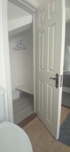 a closet with a white door and a shelf at Up Stairs Double Apartment Innishannon Mariners Rest in Cork