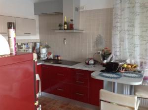 a kitchen with red cabinets and a white counter top at Apartments with parking spaces Sveta Nedelja, Prigorje - 17613 in Sveta Nedelja