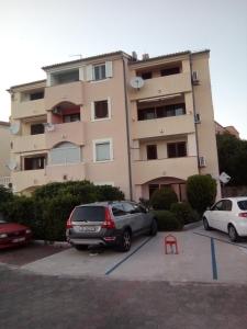 twee auto's geparkeerd op een parkeerplaats voor een gebouw bij Apartments with a parking space Crikvenica - 17675 in Crikvenica