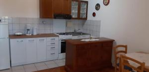 een keuken met witte kasten en een fornuis met oven bij Apartments with a parking space Crikvenica - 17675 in Crikvenica
