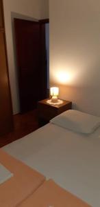 ein Schlafzimmer mit einem Bett und einer Lampe auf einem Nachttisch in der Unterkunft Apartment Crikvenica 17675a in Crikvenica
