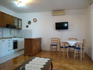 une cuisine avec une table et des chaises ainsi qu'une salle à manger dans l'établissement Apartment Crikvenica 17675a, à Crikvenica