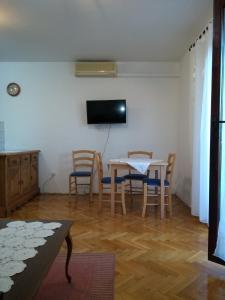 - un salon avec une table, des chaises et une télévision dans l'établissement Apartment Crikvenica 17675a, à Crikvenica