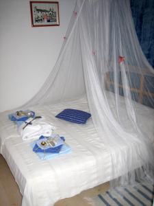 białe łóżko z baldachimem i ręcznikami w obiekcie Family friendly apartments with a swimming pool Kaprije - 17692 w mieście Kaprije