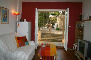 a living room with a white couch and a television at Family friendly apartments with a swimming pool Kaprije - 17692 in Kaprije