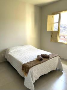 a bedroom with a bed with two towels on it at Casa Ouro no centro de Diamantina in Diamantina