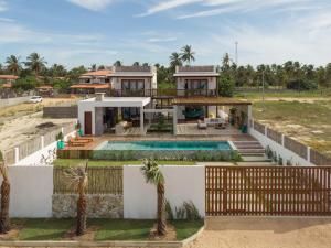 a house on the beach with a swimming pool at Let Village in Amontada