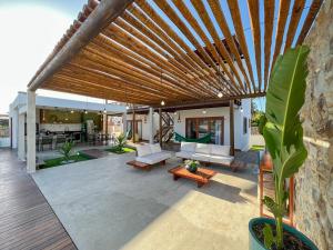 an outdoor patio with a wooden pergola at Let Village in Amontada