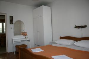 a white bedroom with a bed and a mirror at Apartments by the sea Vinisce, Trogir - 17590 in Vinišće