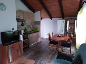 eine Küche und ein Esszimmer mit einem Tisch und einem TV in der Unterkunft Apartments with WiFi Silba - 17603 in Silba
