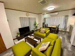 a living room with a green couch and a table at ワンハウス新小岩 in Tokyo