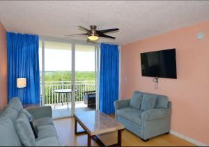 un soggiorno con divano e ventilatore a soffitto di Sunrise Suites by TO a Key West