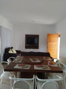 a dining room table with chairs and a television at Rancho do Pedro in Capitólio