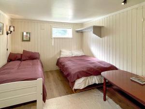 a small bedroom with a bed and a table at Two-Bedroom Holiday home in Laupstad 4 in Vestpollen