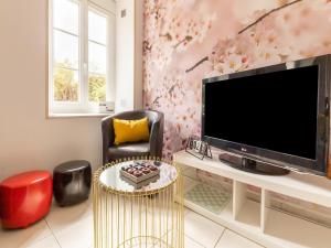 a living room with a tv and a chair and a table at Nice holiday home in Isigny sur Mer with garden in Isigny-sur-Mer