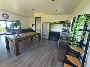 a living room with a table and a kitchen at Tematas Mountain Villa in Avarua