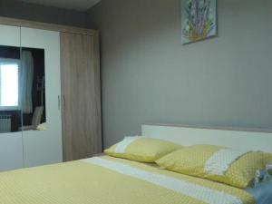 - une chambre avec un lit et 2 oreillers jaunes dans l'établissement Apartments with WiFi Kastel Kambelovac, Kastela - 17732, à Kaštela