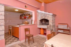 a kitchen with pink walls and a stone oven at Holiday house with a parking space Svirce, Hvar - 17682 in Vrbanj