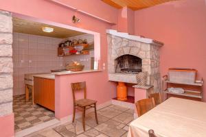eine Küche mit rosa Wänden und einem Steinofen in der Unterkunft Holiday house with a parking space Svirce, Hvar - 17682 in Vrbanj