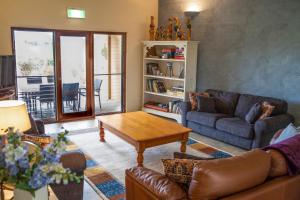 a living room with a couch and a coffee table at Burncroft Guesthouse in Lovedale