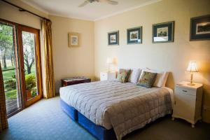 a bedroom with a bed and a sliding glass door at Burncroft Guesthouse in Lovedale