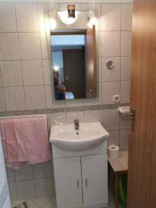 ein Badezimmer mit einem weißen Waschbecken und einem Spiegel in der Unterkunft Apartments with a parking space Vrsi - Mulo, Zadar - 17753 in Vrsi