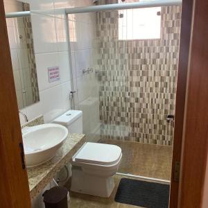 a bathroom with a toilet and a sink and a shower at Pousada Cipó Cana in Santana do Riacho