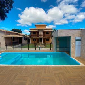 a villa with a swimming pool in front of a house at Pousada Cipó Cana in Santana do Riacho